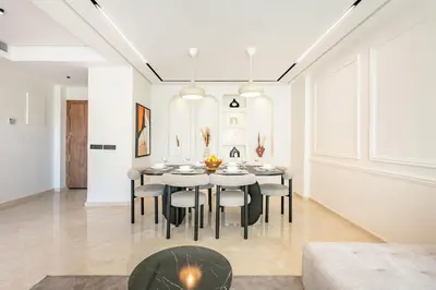 a dining room with white walls and a table and chairs at Bohemian Flat in Marrakech