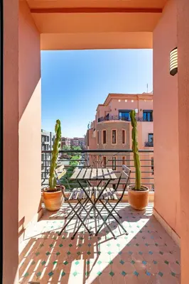 a patio with a table and cactuses on a balcony at Bohemian Flat in Marrakech