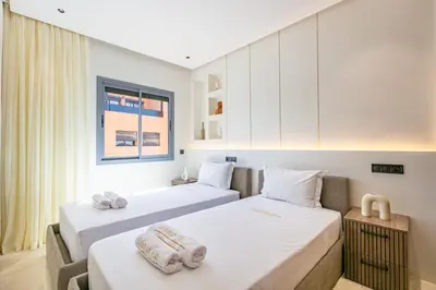two beds in a room with white walls at Bohemian Flat in Marrakech