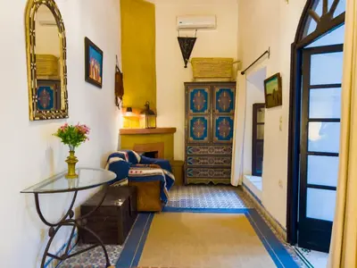 a living room with a table and a door at Riad Amethyste in Marrakech