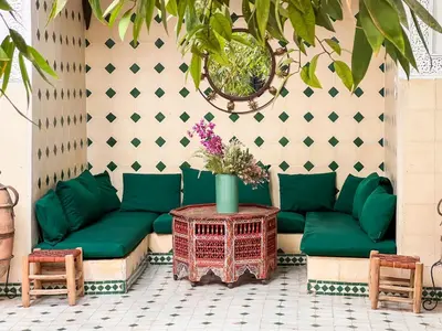a living room with a green couch and two chairs at Riad Amethyste in Marrakech