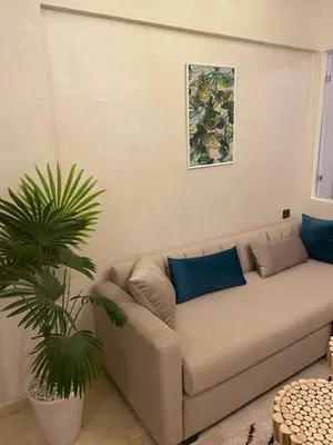 a couch in a living room with a plant at Magnifique & élégant appartement in Marrakech