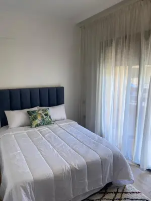a bedroom with a large bed with a large window at Magnifique & élégant appartement in Marrakech