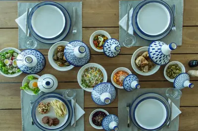 a wooden table with plates and bowls of food at L'Orientale By La Siredrah in Marrakech