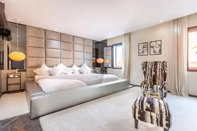 a bedroom with a large bed and a chair at Splendide Villa Lilya in Marrakech