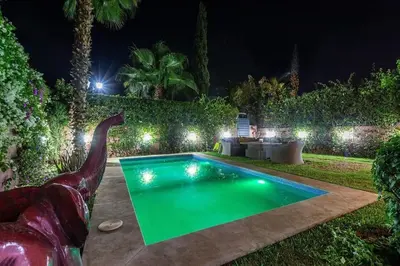 a swimming pool in a yard at night at Splendide Villa Lilya in Marrakech