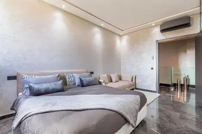 a bedroom with a large bed and a chair at Splendide Villa Lilya in Marrakech