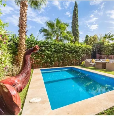 a swimming pool in a yard with a statue next to it at Splendide Villa Lilya in Marrakech