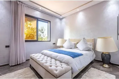 a bedroom with a large bed and a window at Splendide Villa Lilya in Marrakech