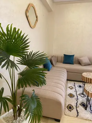 a living room with a couch and two palm trees at Luxury & cosy apartment in Marrakech
