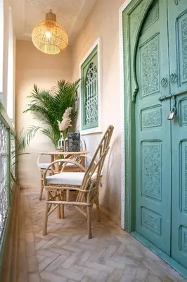 a porch with a table and chairs and a blue door at Riad Chic in Marrakech