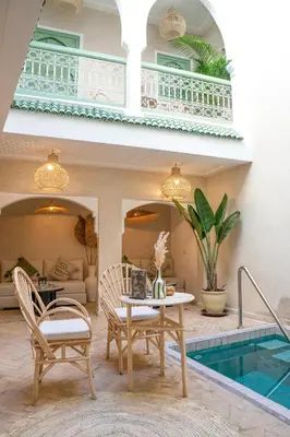 a patio with a table and chairs and a pool at Riad Chic in Marrakech