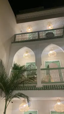 a room with two chandeliers and a palm tree at Riad Chic in Marrakech