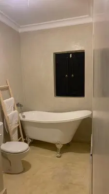 a bathroom with a tub and a toilet and a sink at Riad Chic in Marrakech