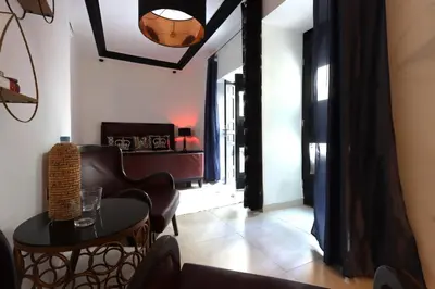 a living room with a table and a chair at Riad Modern Bed & Breakfast - Top location in Marrakech