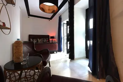 a living room with a table and a chair at Riad Modern Bed & Breakfast - Top location in Marrakech