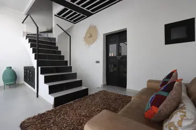 a living room with a couch and a staircase at Riad Modern Bed & Breakfast - Top location in Marrakech