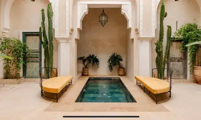 a swimming pool in a room with cactus at Riad Manzal in Marrakech