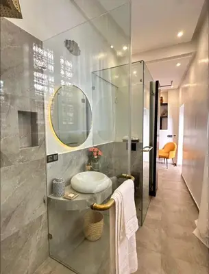 a bathroom with a sink and a glass shower at Riad Manzal in Marrakech