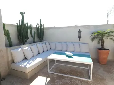 a couch and a table in a room with cactus at Riad Coconut in Marrakech