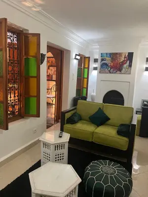 a living room with a green couch and stained glass windows at Riad Le Roy’s in Marrakech