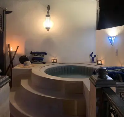 a large bath tub in a room with a light at Riad Le Roy’s in Marrakech