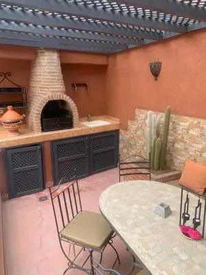 a patio with a table and a pizza oven at Riad Le Roy’s in Marrakech