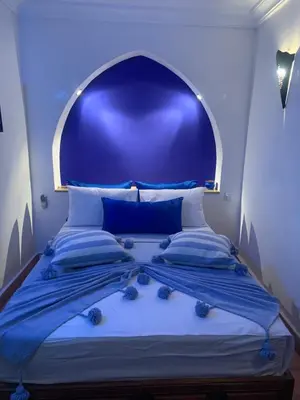 a blue bedroom with a bed with a blue headboard at Riad Le Roy’s in Marrakech