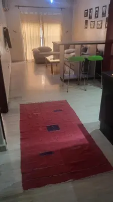a red rug on the floor of a living room at hamza in Marrakech