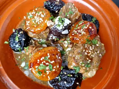 an orange bowl of food with tomatoes and sesame seeds at RIAD SAMAH in Marrakech