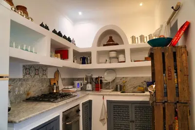 a kitchen with white shelves and a stove top oven at Riad l'Echappée, en exclusivité, 5 chambres in Marrakech