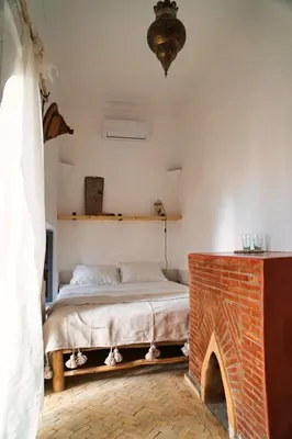 a bedroom with a bed and a brick fireplace at Riad l'Echappée, en exclusivité, 5 chambres in Marrakech