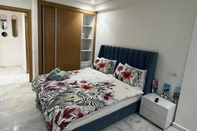a bedroom with a bed with a floral bedspread at 1 Bed Apartment - Balcony Wifi Parking in Marrakech