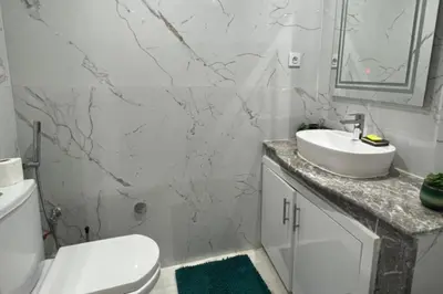 a white bathroom with a toilet and a sink at 1 Bed Apartment - Balcony Wifi Parking in Marrakech