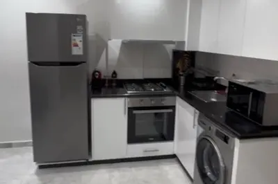 a small kitchen with a stove and a refrigerator at 1 Bed Apartment - Balcony Wifi Parking in Marrakech