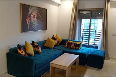 a blue couch in a living room with a table at 1 Bed Apartment - Balcony Wifi Parking in Marrakech