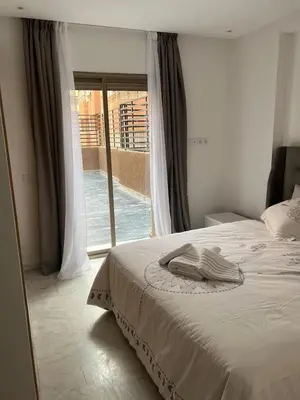 a bedroom with a bed and a sliding glass door at 1Bed Apartment - Sleeps 4 - Balcony Wifi Parking in Marrakech