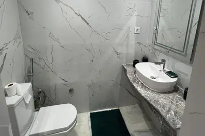 a white bathroom with a toilet and a sink at 1Bed Apartment - Sleeps 4 - Balcony Parking Wifi in Marrakech