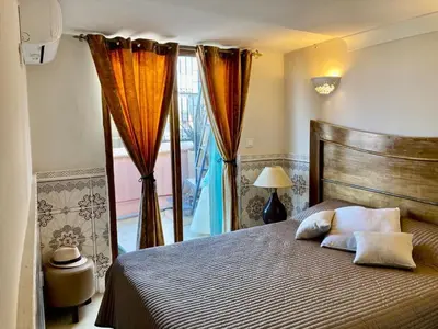 a bedroom with a bed and a window with curtains at MAISON PROCHE DANS LA MEDINA MARRAKECH in Marrakech