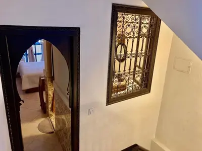 a mirror hanging on a wall next to a hallway at MAISON PROCHE DANS LA MEDINA MARRAKECH in Marrakech