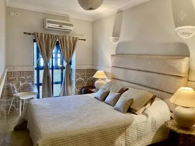 a bedroom with a large bed and a window at MAISON PROCHE DANS LA MEDINA MARRAKECH in Marrakech
