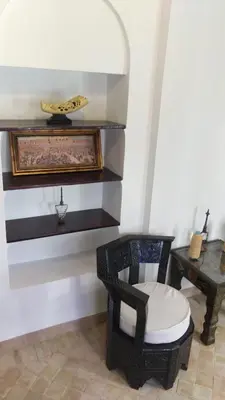 a room with a chair and a table at Ryad Petit Palmier in Marrakech