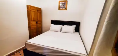 a small bedroom with a bed with white sheets and pillows at Riad 1954 in Marrakech