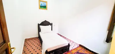 a small bed in the corner of a room at Riad 1954 in Marrakech