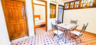 a room with a table and chairs and a door at Riad 1954 in Marrakech