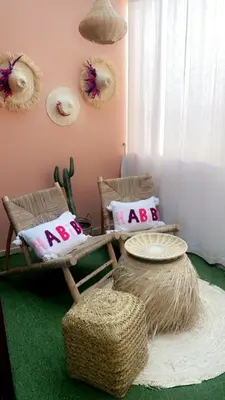 a room with two chairs and two ottomans with pillows at Bel appartement au centre gueliz in Marrakech