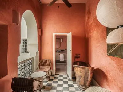 a room with orange walls and a checkered floor at Riad Brummell Medina in Marrakech