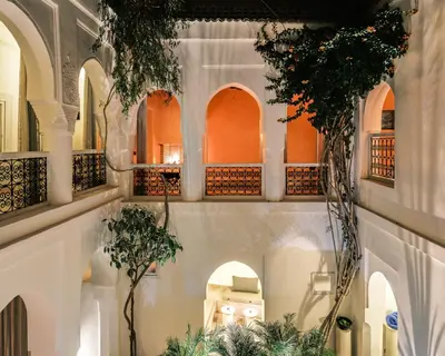 a courtyard with arches and plants in a building at Riad Brummell Medina in Marrakech