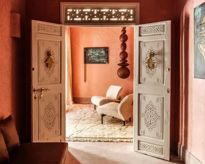 an open door into a living room with a chair at Riad Brummell Medina in Marrakech