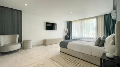 a bedroom with a large bed and a chair at Duplex IKA - Appartement design à Marrakech in Marrakech